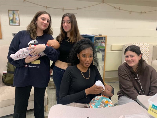 High School student holding a computerized baby