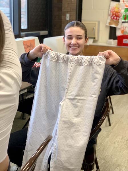 student holding pajamas