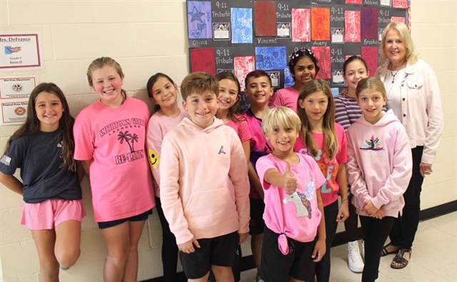 Students wearing pink and smiling