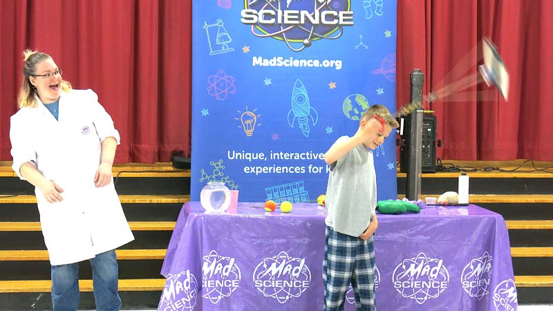 Student doing science experiment on stage