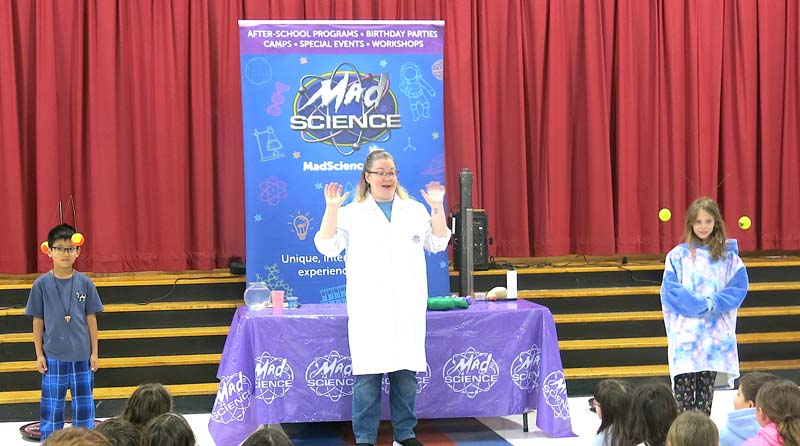 Students doing science experiment on stage