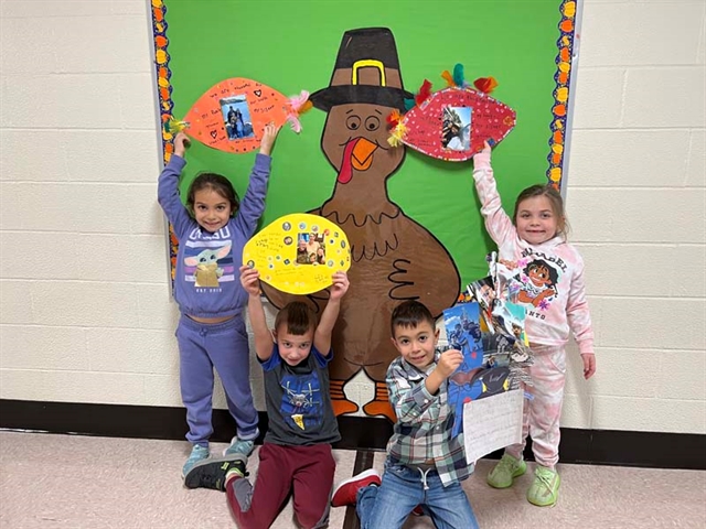 Students posing in front of cutout Turkey which they designed