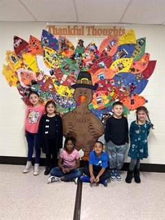 Students posing in front of cutout Turkey which they designed