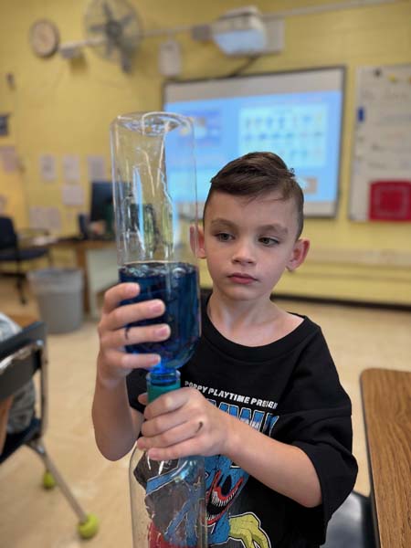 Student shaking a bottle with liquid