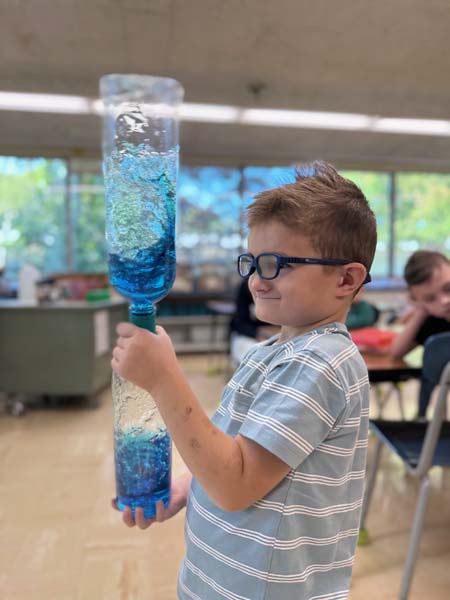 Student shaking a bottle with liquid