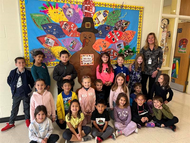 Students posing in front of cutout Turkey which they designed