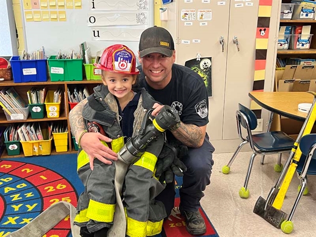 Firefighter posing with student