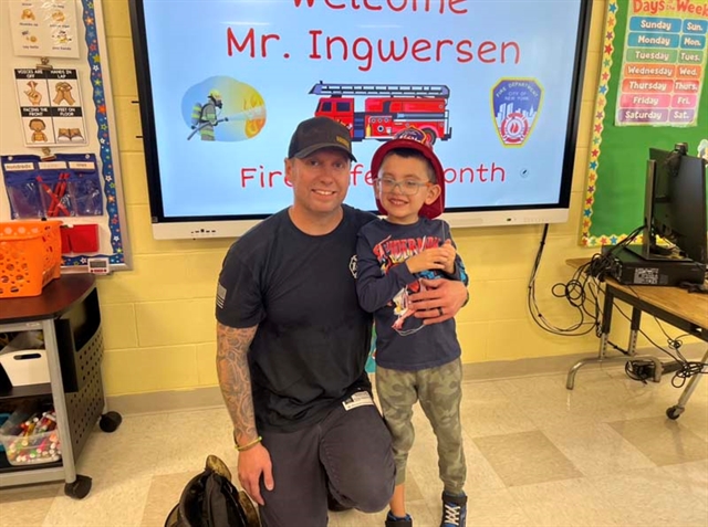 Firefighter posing with student