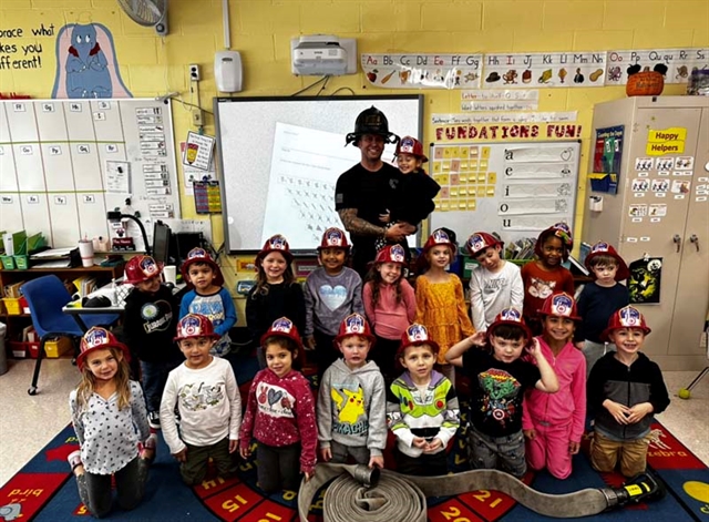 Firefighter posing with students