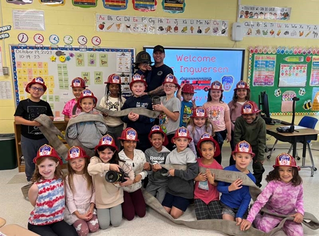 Firefighter posing with students