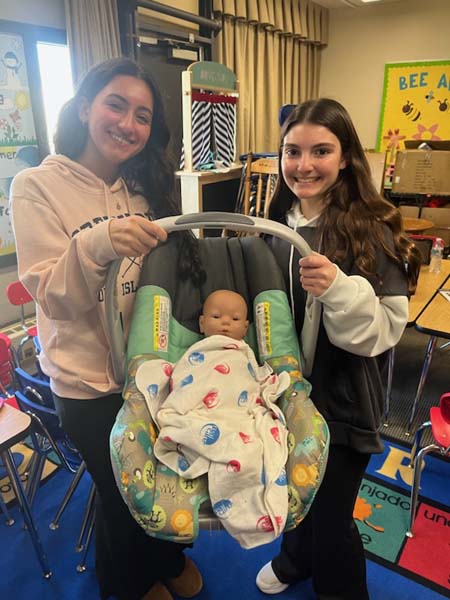 High School student holding a computerized baby