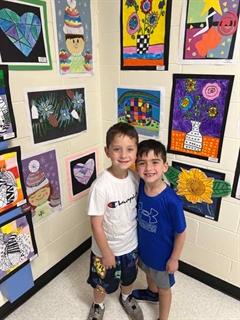 Students smiling in front of artwork