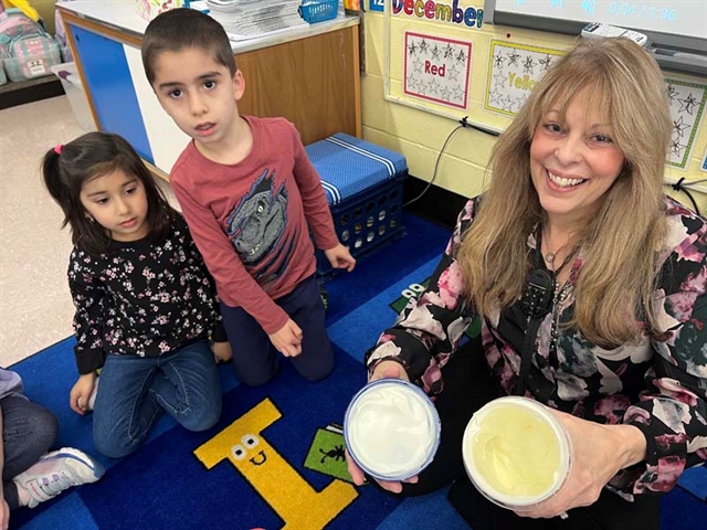 Students churning butter smiling