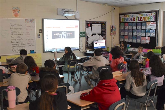 Students watching NASA expert on screen