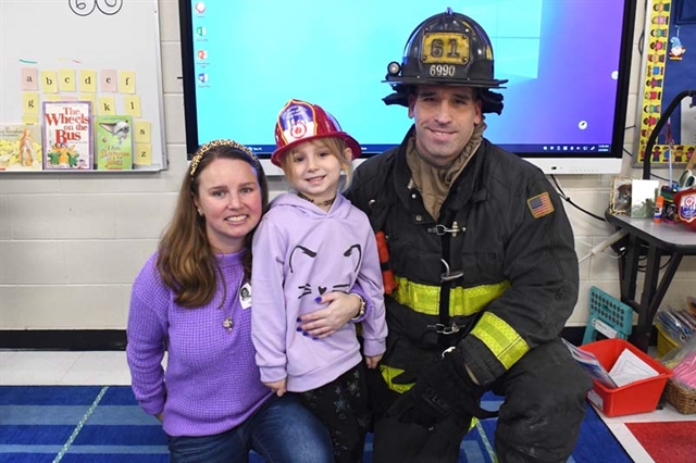 Firefighter dad, mom, and daughter posing for a picture