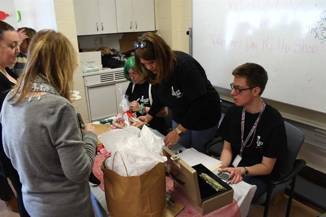 Students checking out customers