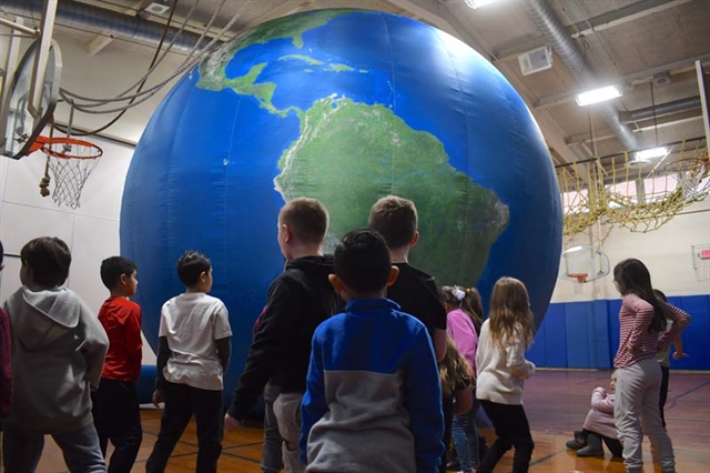 Students by inflatable globe