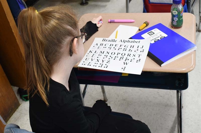 student looking at braille chart