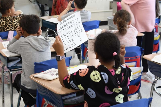 student looking at braille alphabet