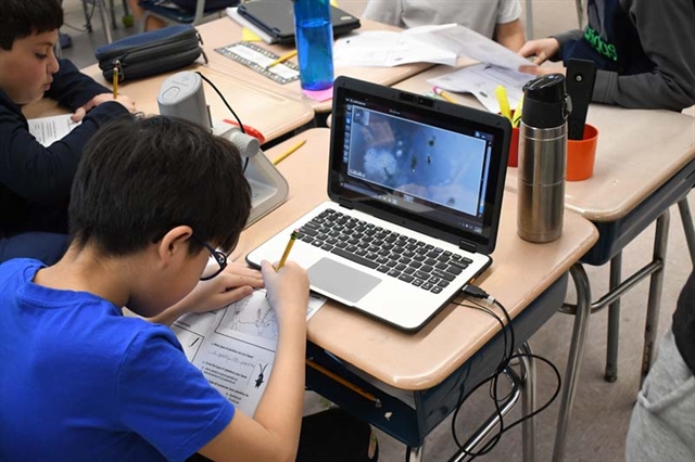 student using microscope