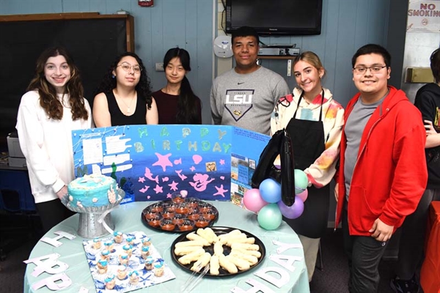 Students posing for picture by their display