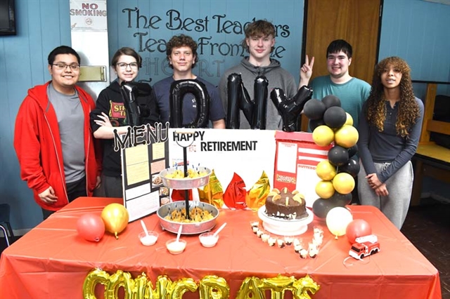 Students posing for picture by their display