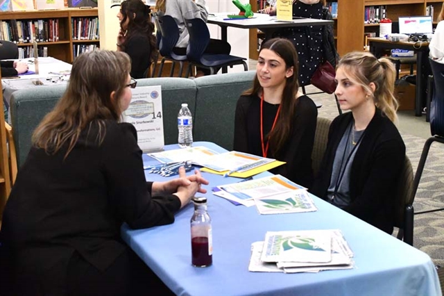 students at desk networking