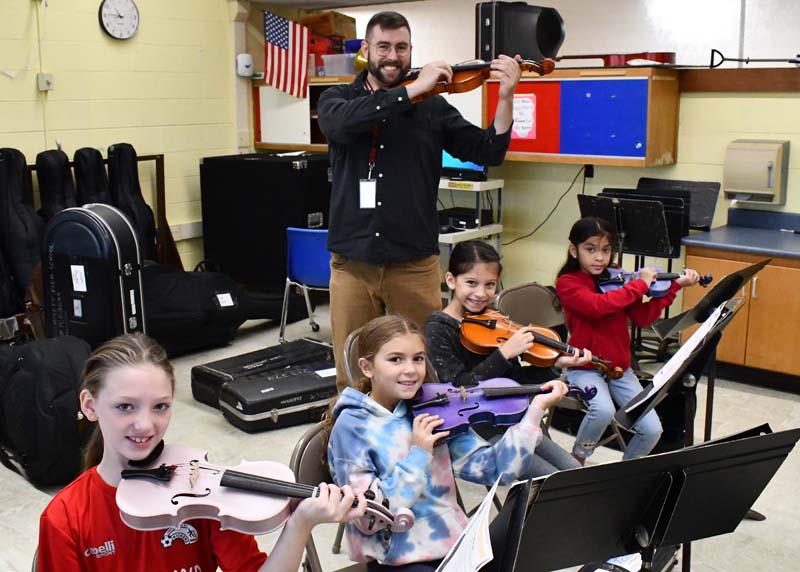 Mr. Mastrangelo with four students playing violin