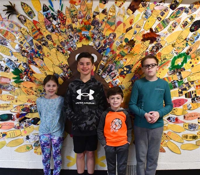 Students posing in front of artwork
