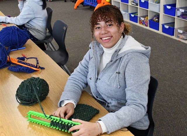 student knitting scarves