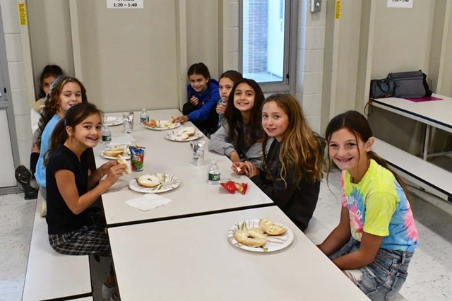 students eating breakfast and smiling