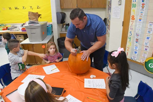 Parents helping pumpkin carving