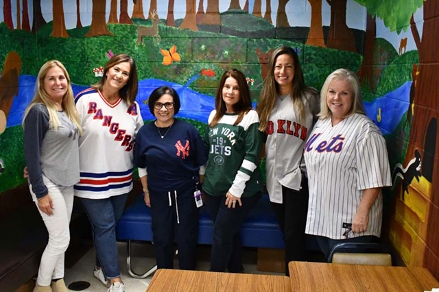 Staff posing for picture wearing sports jerseys