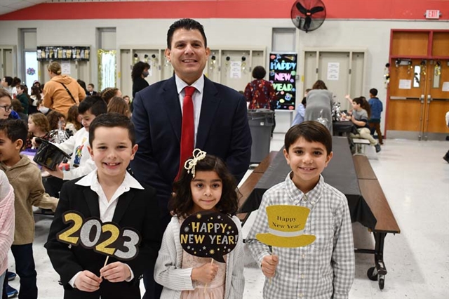 Students and principal smiling for Happy New Year