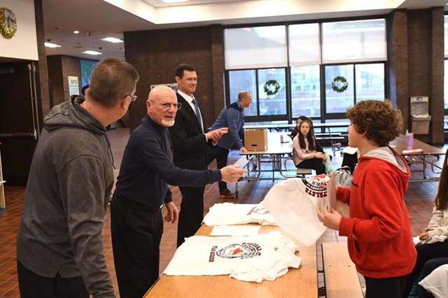 Student receiving shirt and certificate