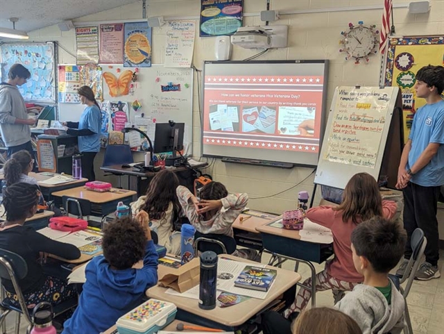 High School students teaching about Veterans Day to elementary students