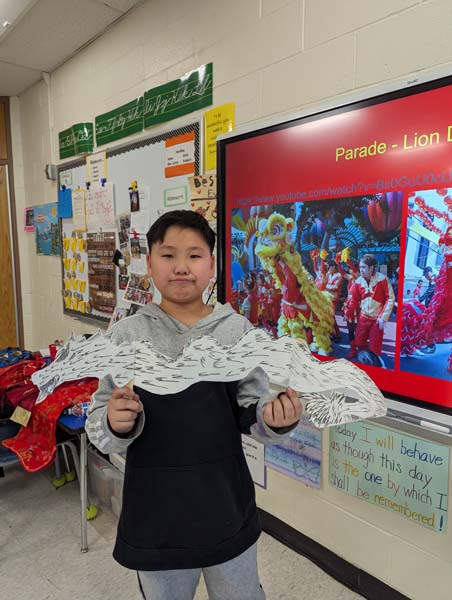 Student holding paper dragon