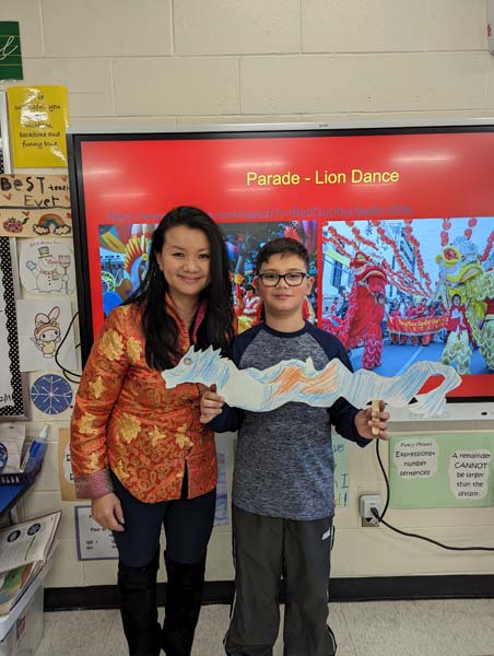 Student and parent holding paper dragon