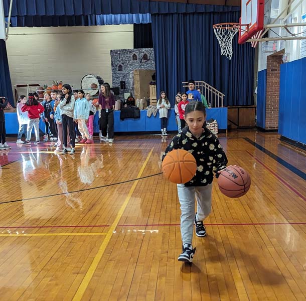 students dribbling a basketball