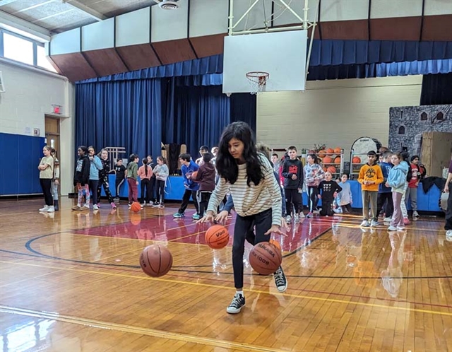 students dribbling a basketball