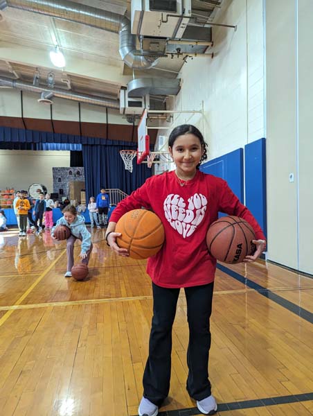 Student posing with basketballs for a picture