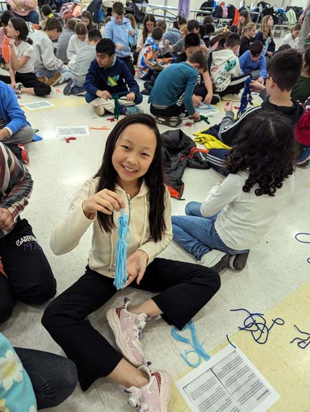 Student holding yarn doll