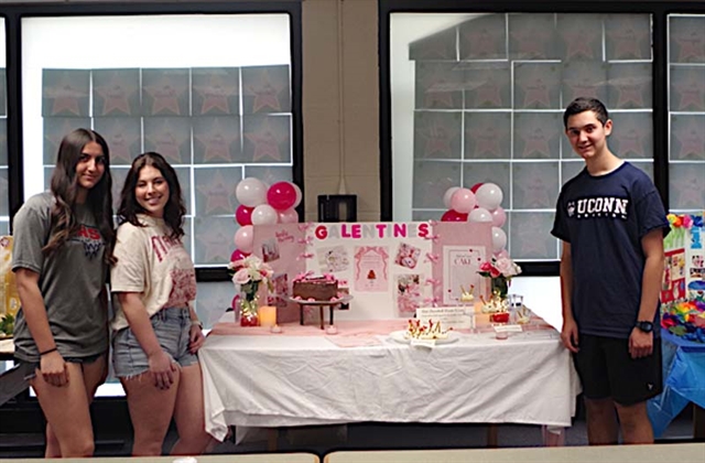Students posing by table