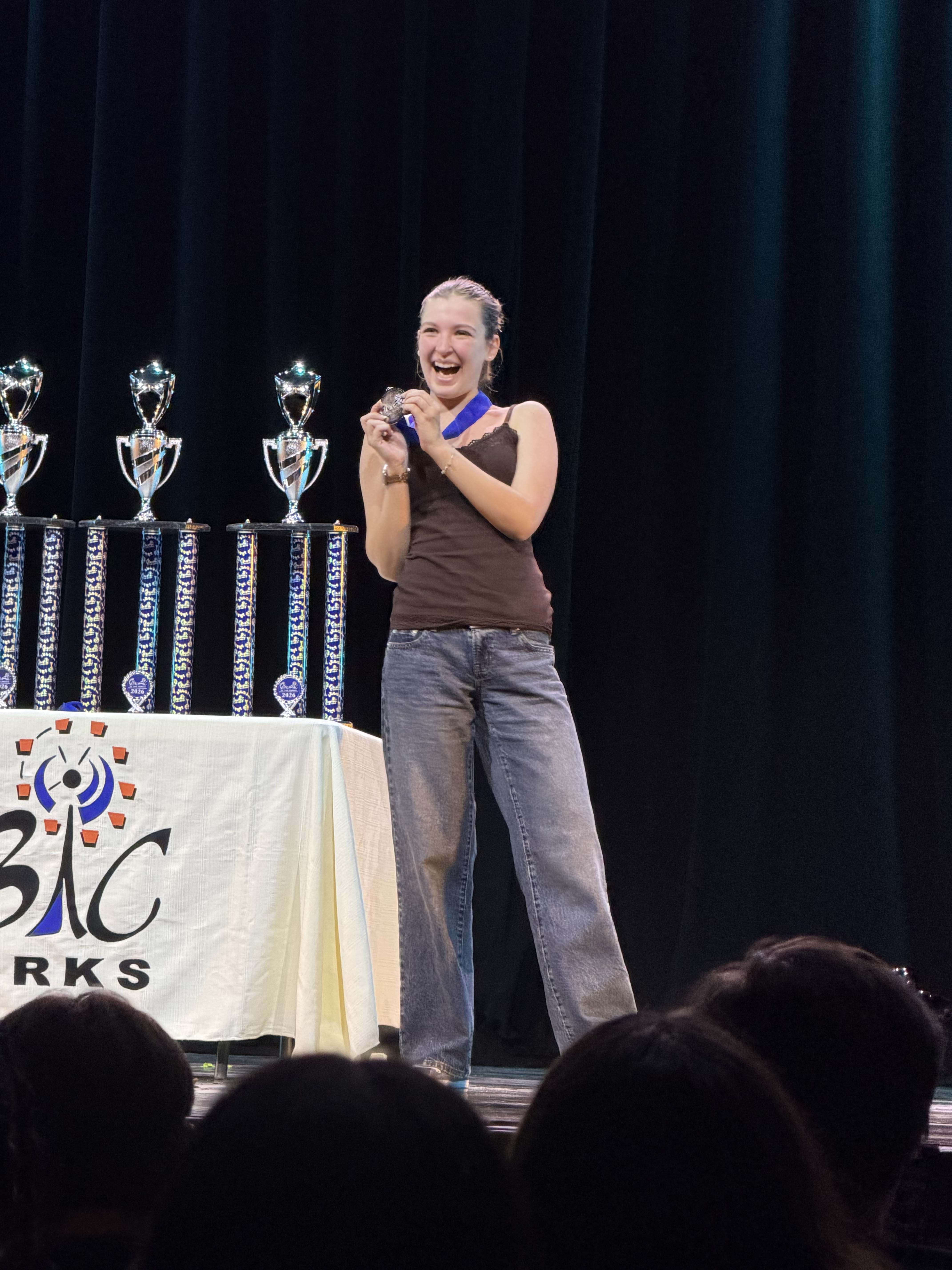 student on stage with award