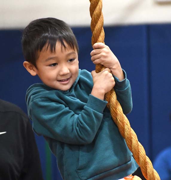 student holding on to rope