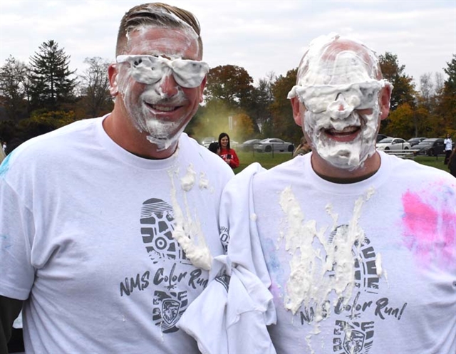 Principal McCabe and AP Derek Solomon smiling with pie on their faces