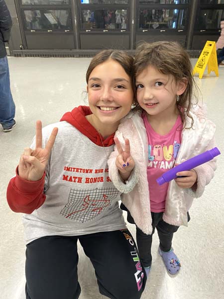 HS student and younger student smiling