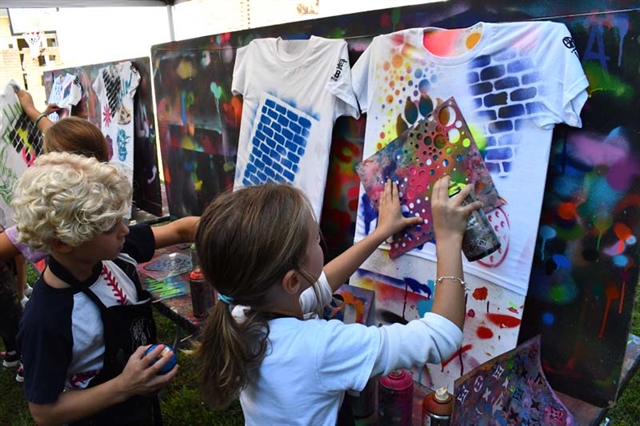 Student smiling next to art project