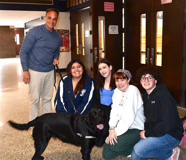 group posing for picture with dog