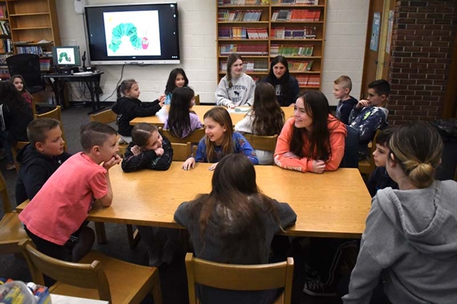 HS students teaching sign language to elementary students